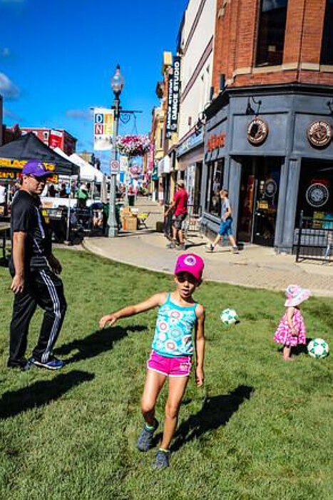 Child playing on grass in a downtown area