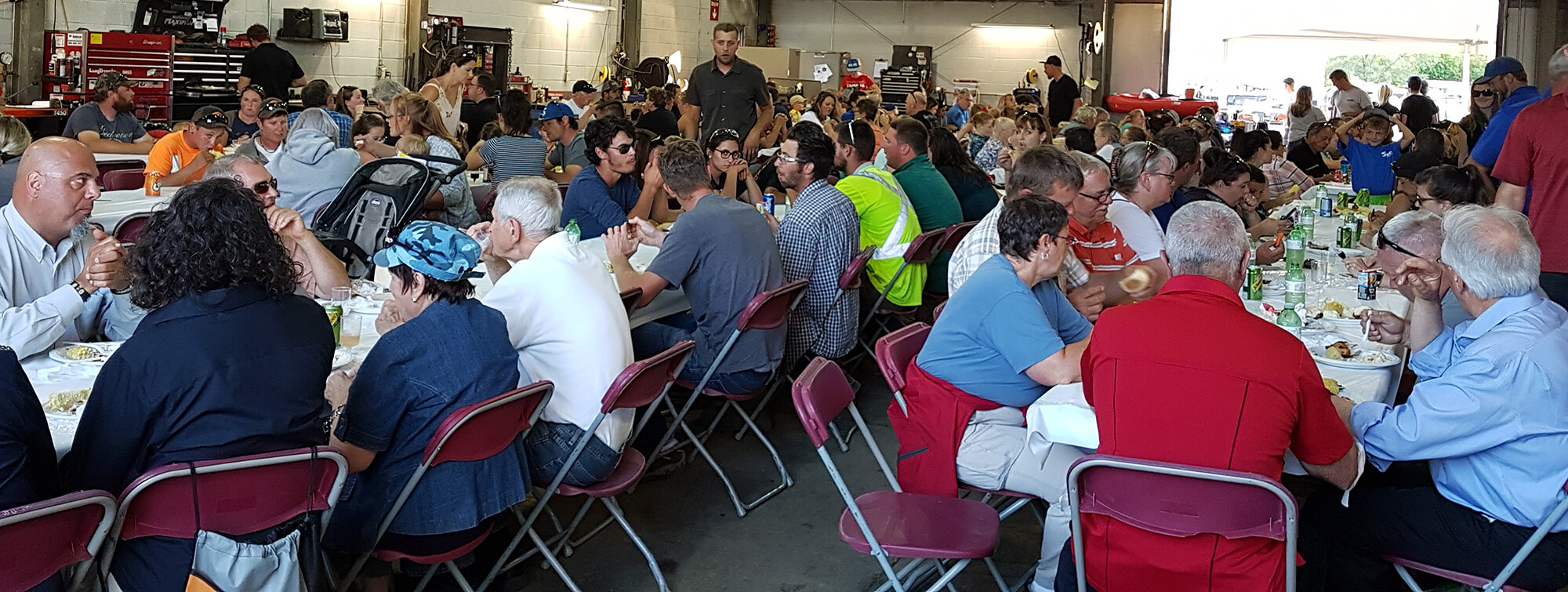 large barn with people at tables eating dinner