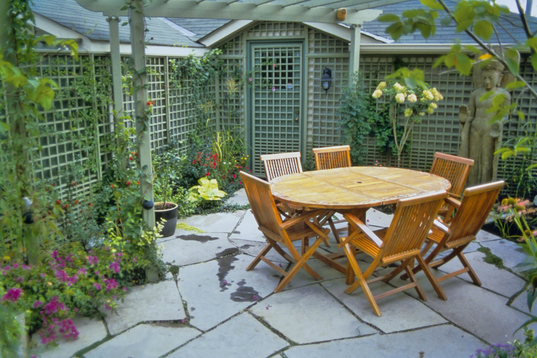 award winning backyard garden with table chairs and lattice