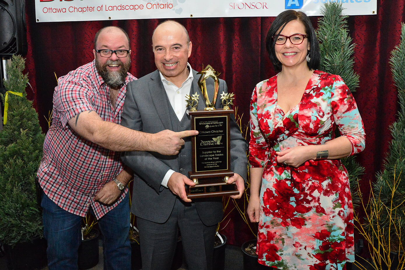 three people holding an award