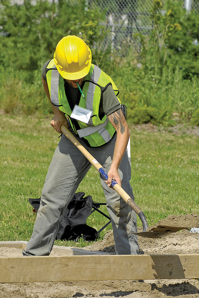 man in construction clothes performing a test of ability outside