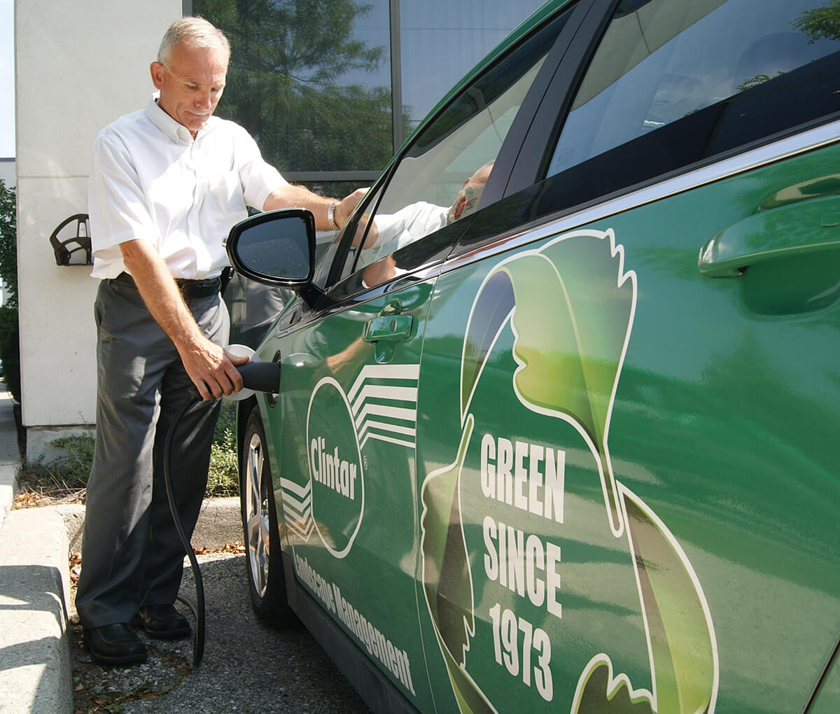 man pluggin in an electric car