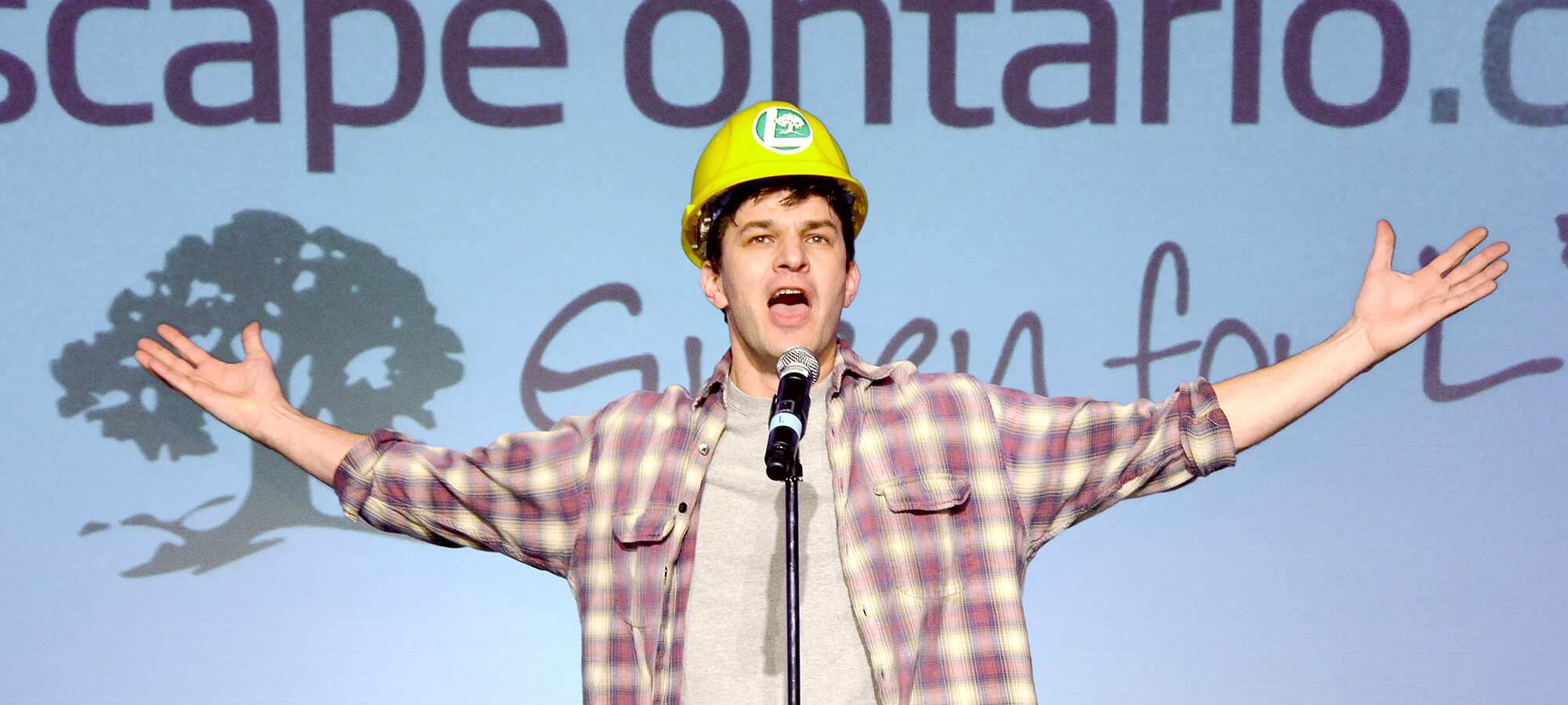 man in a construction hat on stage performing