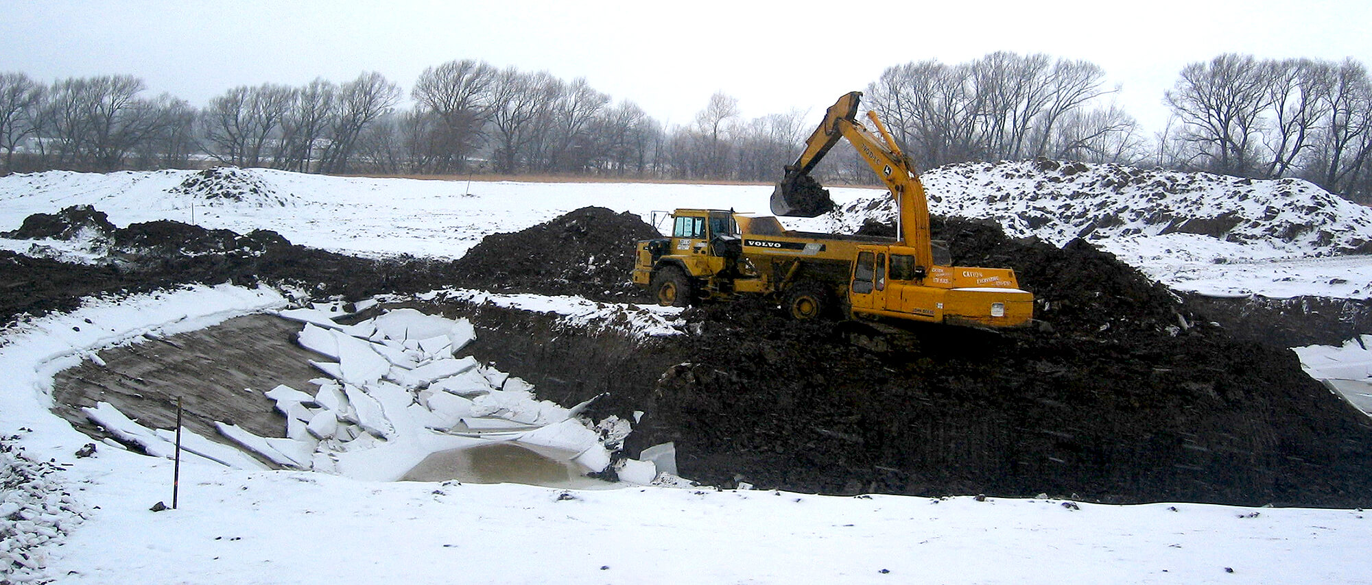 excavator working in a field in winter