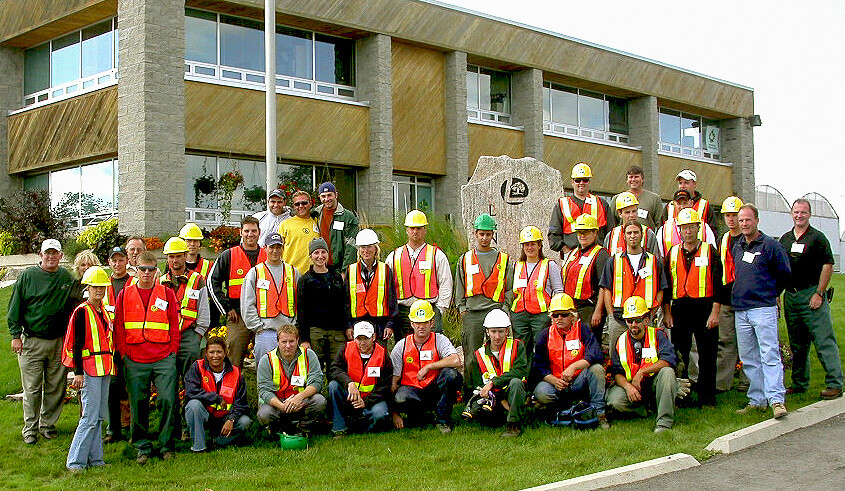 large group of people wearing construction vests and hard hats