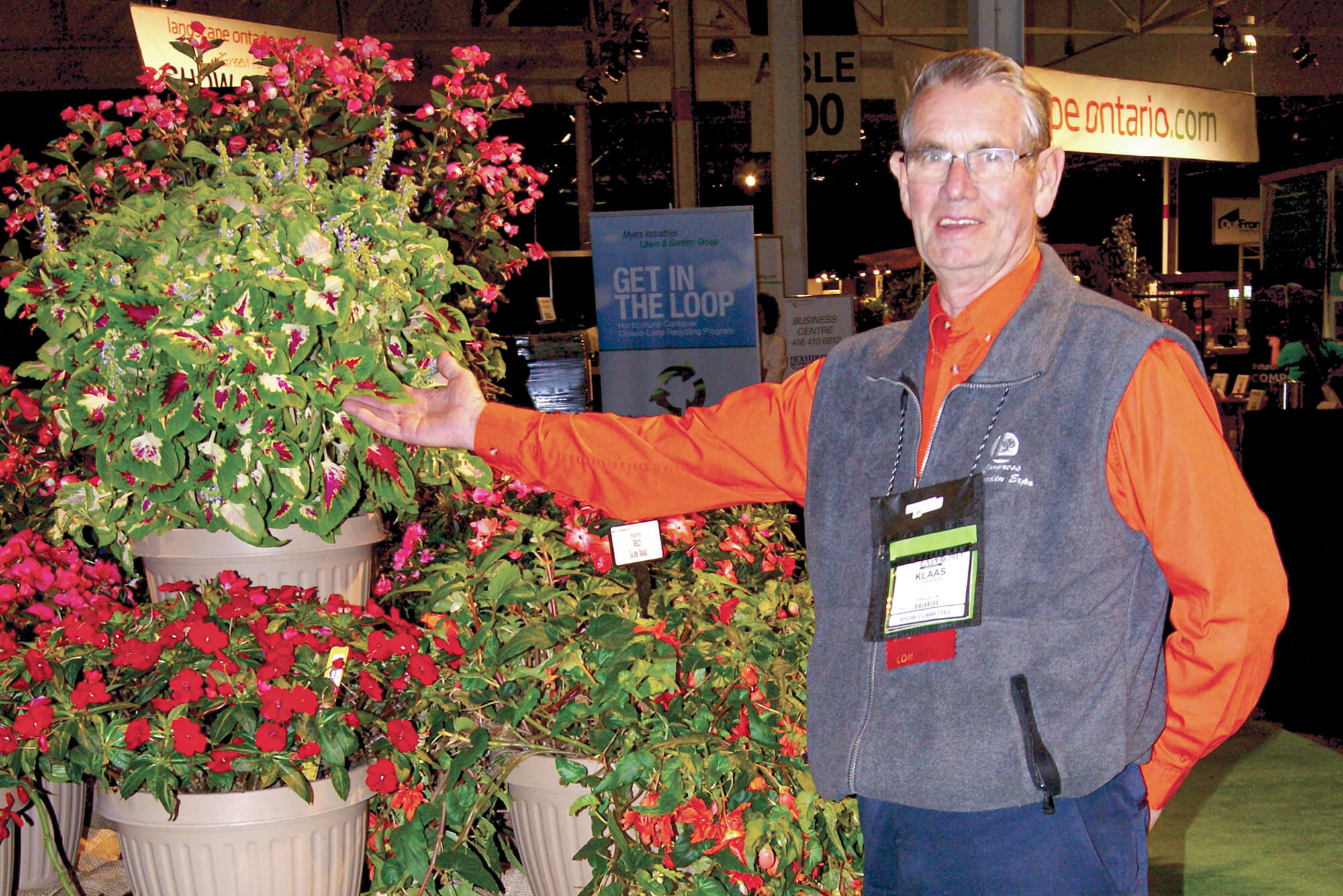 man standing next to a display of plants