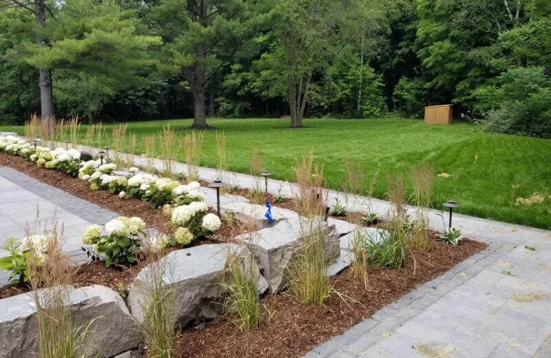 garden with mulch, natural stone, grasses, plants and lights