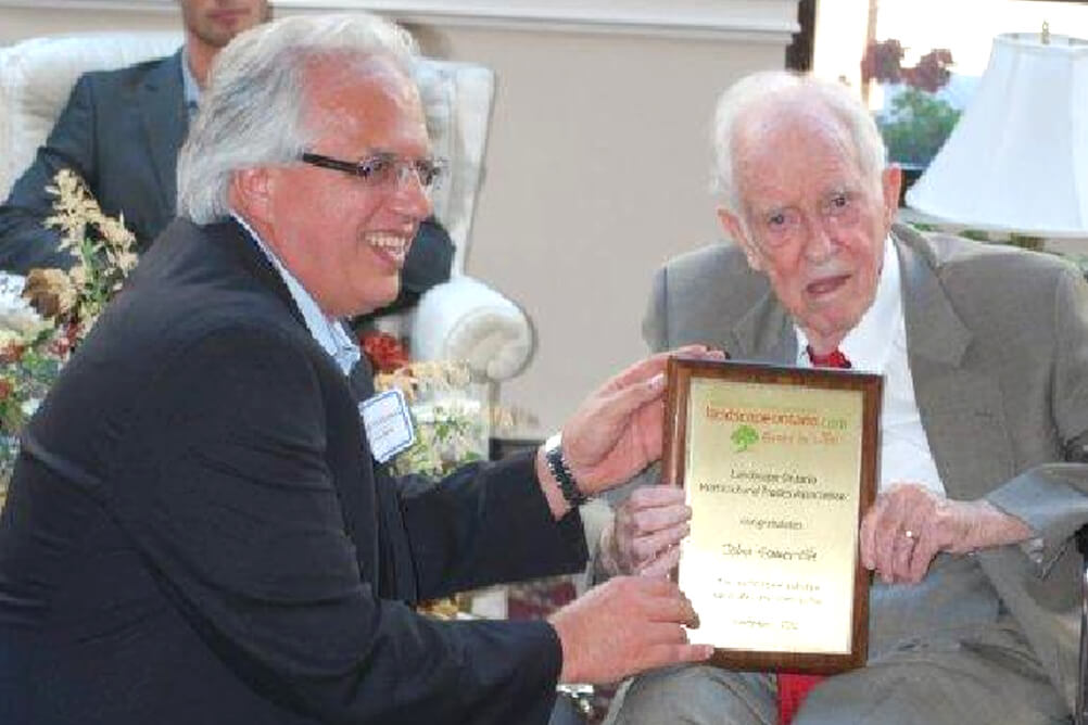 man presenting an older man with a plaque