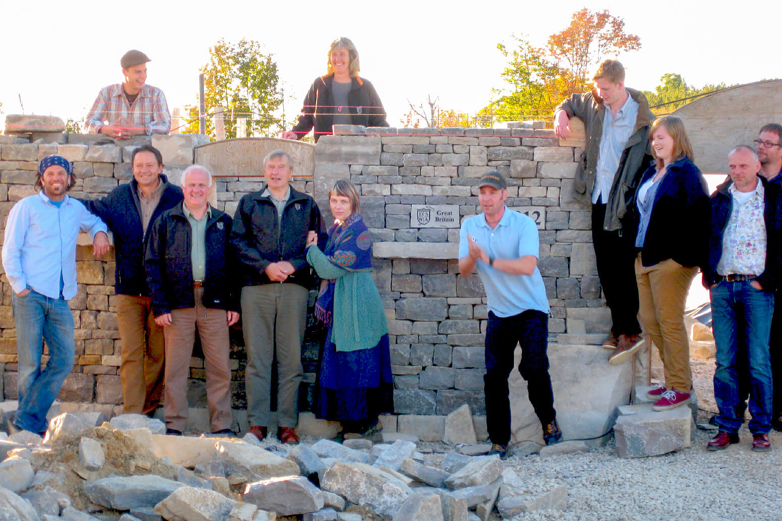 large group of people in front of a stone wall