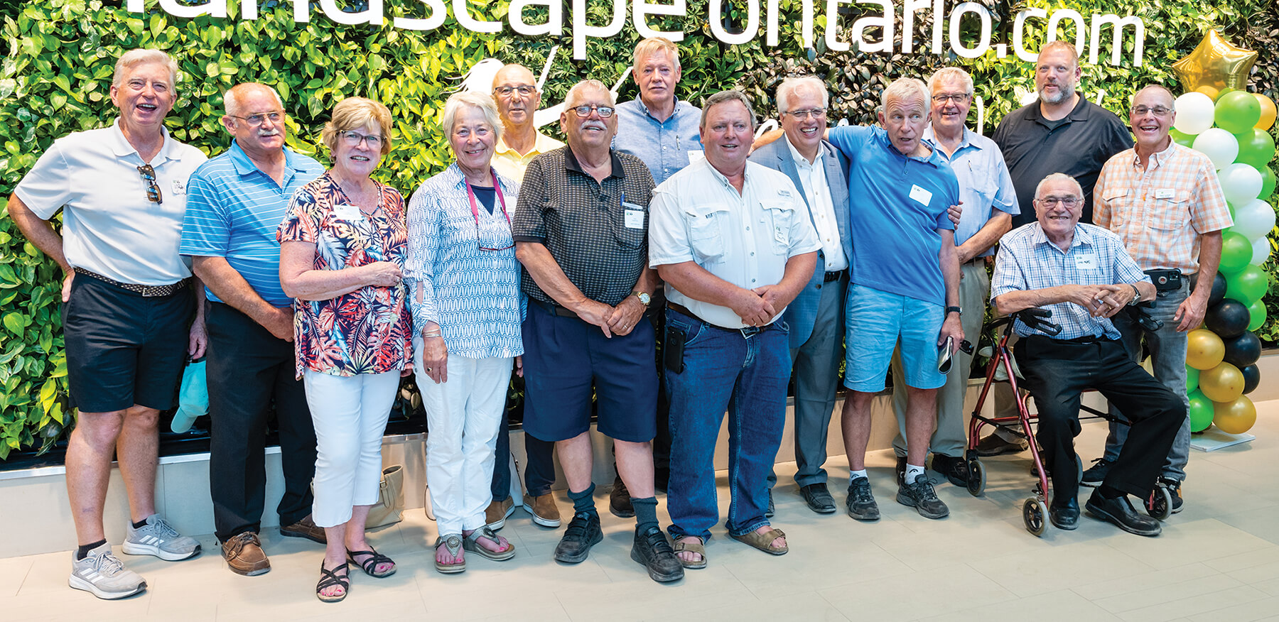 group of people in front of a living wall